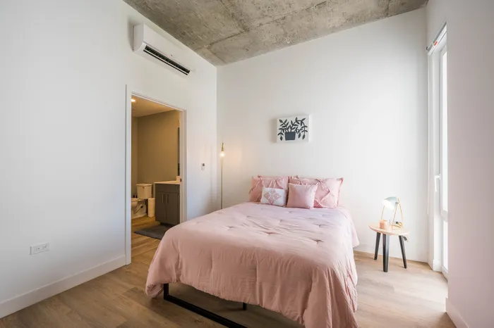 2 Bedroom Student Apartments in Lincoln Park, Chicago, IL | Post Chicago | Bedroom Featuring Air Conditioning and High Ceilings with Exposed Concrete