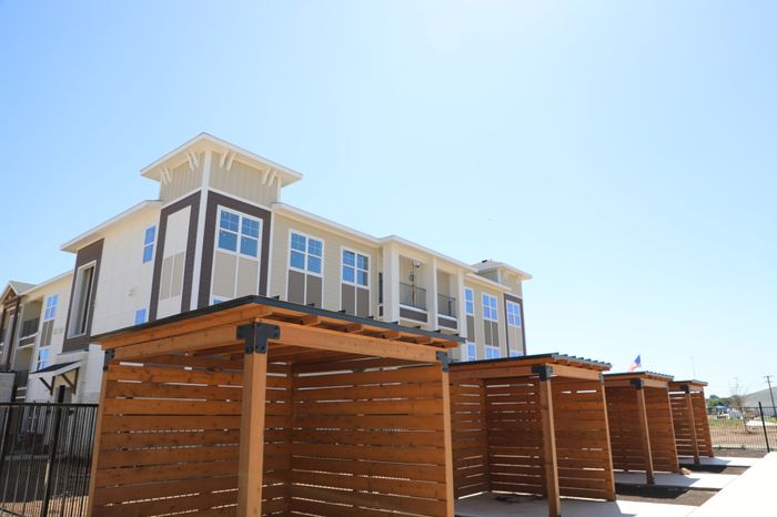 Charming modern apartment with stylish architecture and attractive wooden pergolas under a clear blue sky.