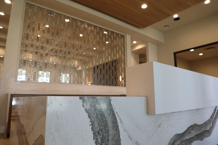 Contemporary interior showcasing a stylish marble countertop and elegant decorative wall panel with geometric patterns.
