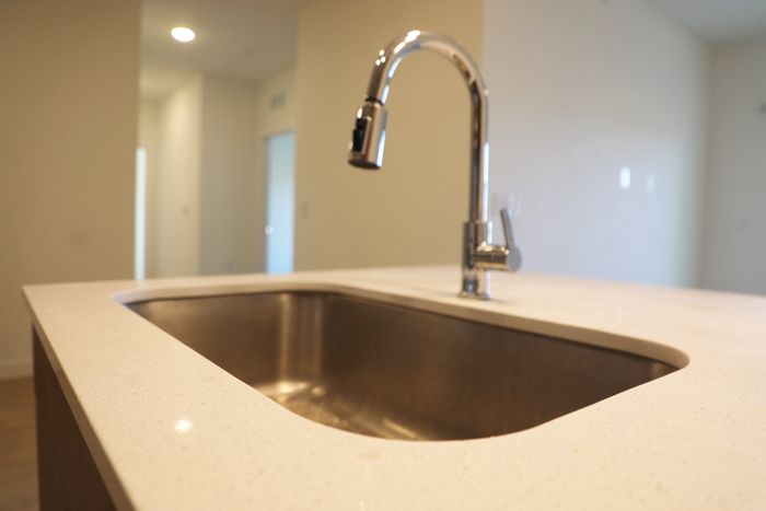 Sleek modern kitchen sink with a polished chrome faucet in a stylish apartment setting.