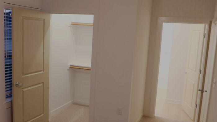Bedroom with a walk-in closet and a doorway leading to a private bathroom