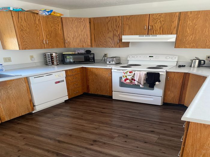 Charming kitchen with wooden cabinets, an electric stove, and modern appliances.