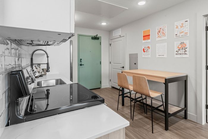 Contemporary kitchen with sleek appliances, stylish dining nook, and modern wall art, perfect for urban living.