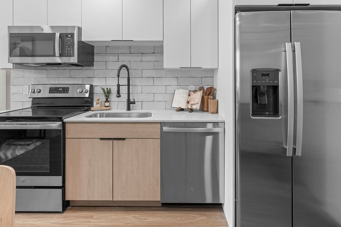 Modern kitchen with sleek stainless steel appliances, stylish cabinetry, and elegant backsplash.