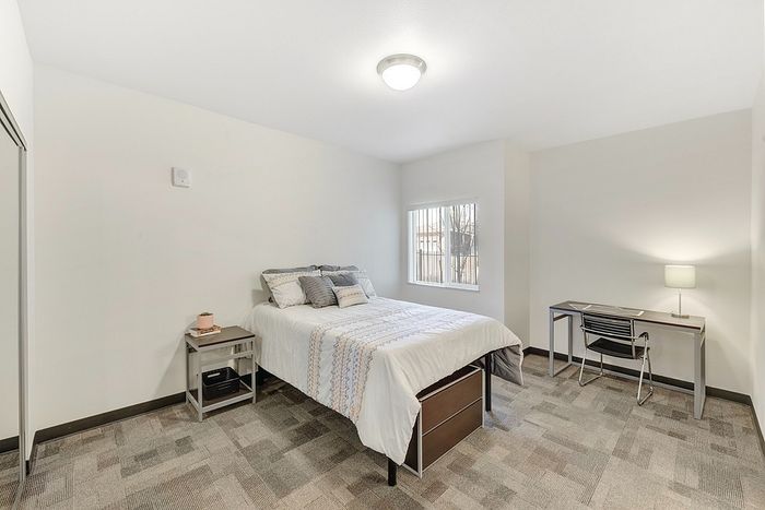 Bright, modern bedroom with stylish decor and a convenient workspace, perfect for relaxation and productivity.