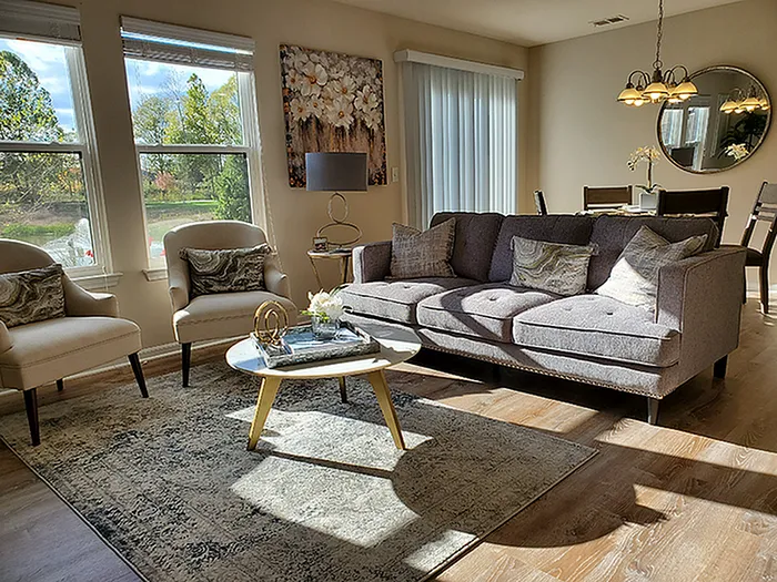 Bright and inviting living room featuring elegant decor, plush seating, and abundant natural light from large windows, perfect for relaxation and gatherings.