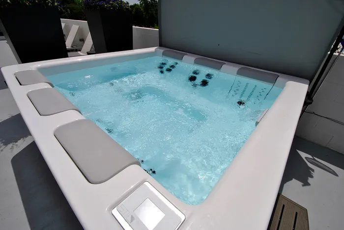 Luxurious rooftop hot tub with bubbling jets, surrounded by sleek modern design and beautiful outdoor views.