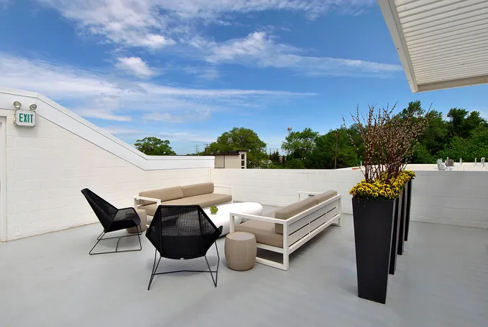 Inviting rooftop terrace with modern seating, lush greenery, and dramatic skies, ideal for relaxation and entertaining.
