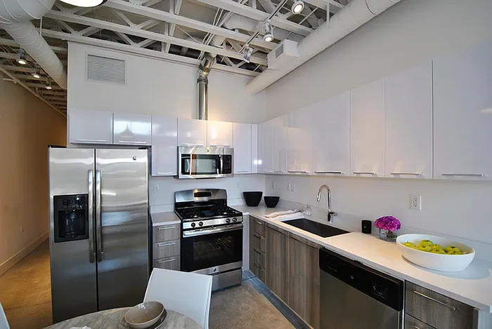 Contemporary kitchen featuring sleek stainless steel appliances, modern cabinetry, and stylish open shelving in a bright, spacious layout.