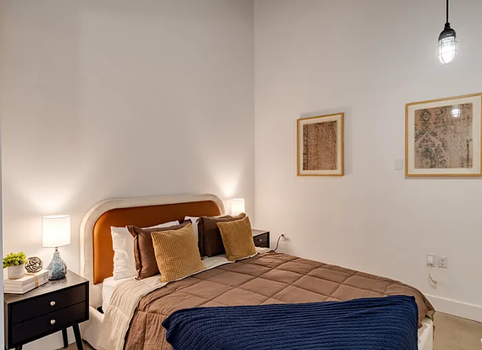 Cozy bedroom with elegant lighting, plush bed, and stylish decor creating a warm and inviting atmosphere.