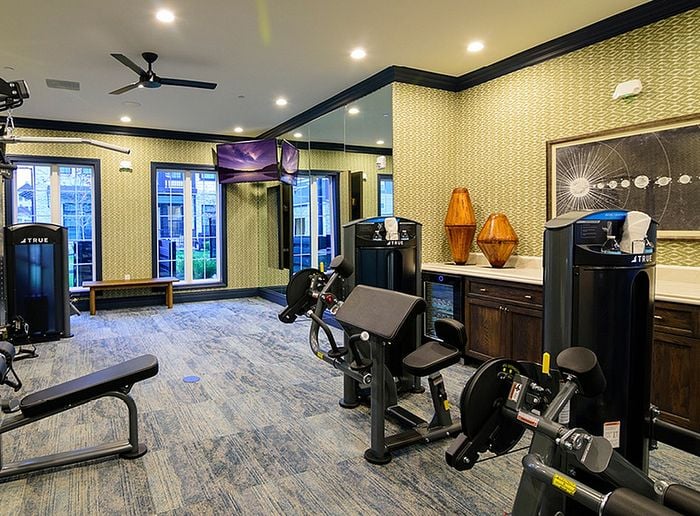 Modern apartment gym featuring state-of-the-art fitness equipment, bright lighting, and elegant decor for a stylish workout experience.