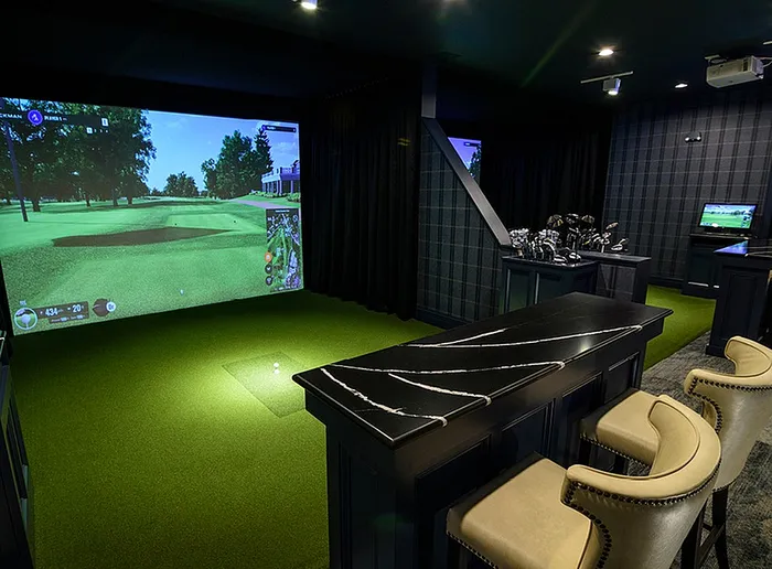 Luxurious indoor golf simulator room with elegant seating and advanced virtual golf screen for immersive play.