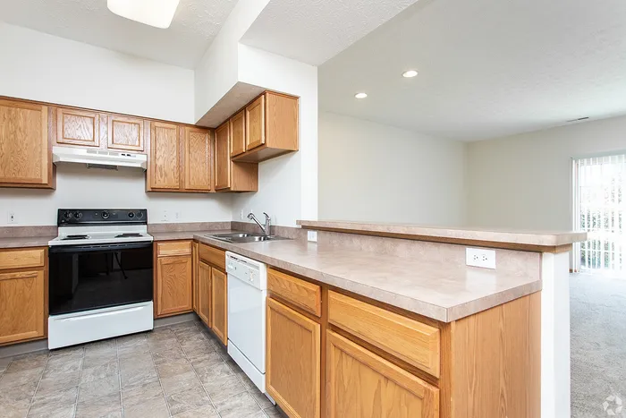 Bright kitchen with sleek wooden cabinets, modern appliances, and a spacious countertop ideal for dining and entertainment.