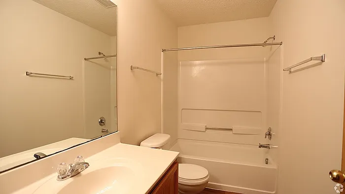 Bright and spacious bathroom with modern sink, elegant mirror, and pristine bathtub.