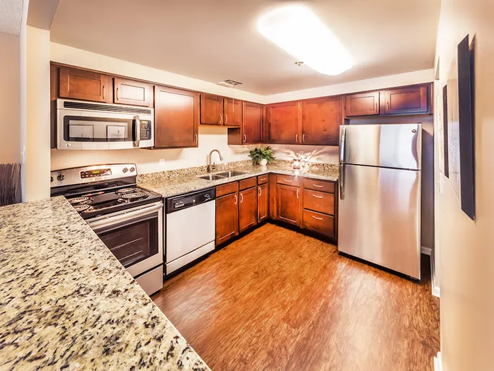 Modern kitchen with stainless steel appliances, granite countertops, and rich wood cabinetry, offering a spacious and inviting cooking experience.