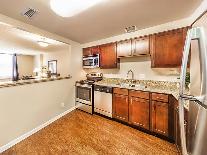 Modern kitchen with stainless steel appliances, sleek granite countertops, and elegant wooden cabinets.