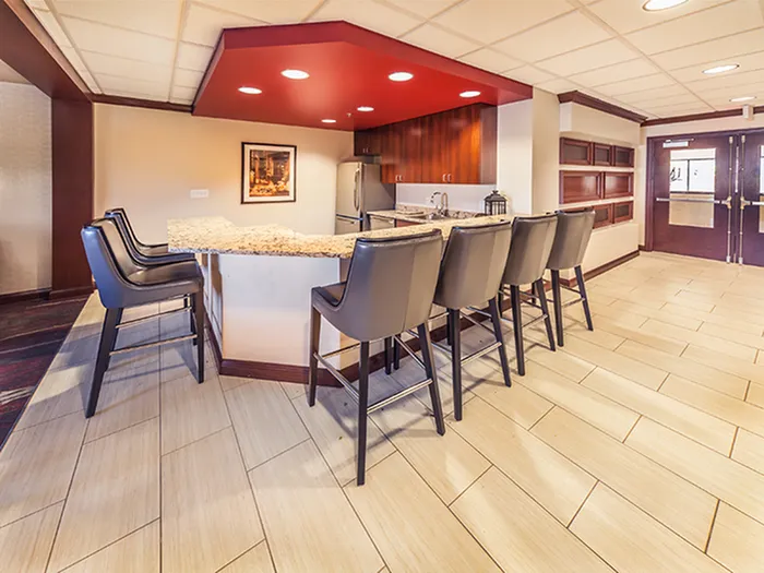 Inviting modern kitchen with a sleek granite countertop, stylish bar seating, and warm wood cabinetry.