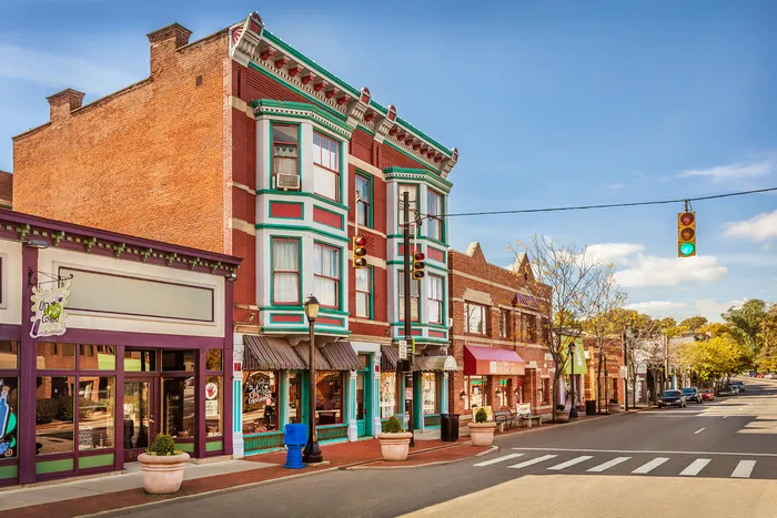 Charming small-town street scene with beautifully preserved historic brick buildings and vibrant storefronts, perfect for boutique shopping and leisurely strolls.