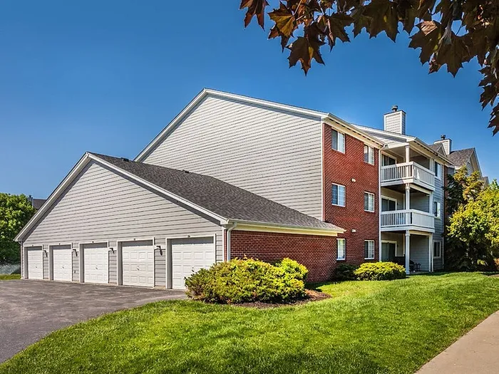Charming brick apartment complex with spacious balconies and beautiful landscaping, offering a peaceful residential environment.