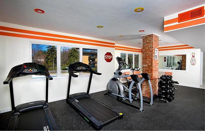 Bright and modern gym with treadmills, an elliptical machine, and free weights, offering a dynamic workout environment.