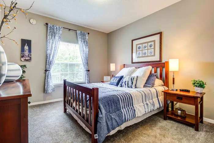 Inviting bedroom with ample natural light from a large window, perfect for relaxation.