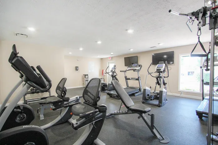 Modern fitness center with state-of-the-art gym equipment, including treadmills and exercise bikes, in a bright and inviting space.