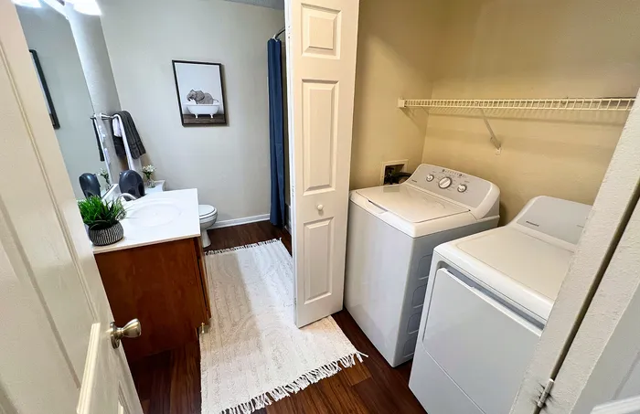 Modern bathroom with in-unit washer and dryer, elegant vanity for convenient living.