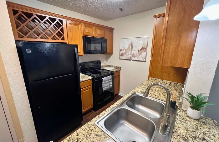 Modern kitchen with sleek granite countertops, elegant wooden cabinetry, and stainless steel fixtures, offering a stylish yet functional cooking space.