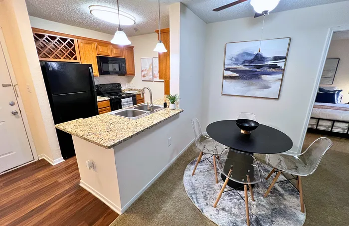 Chic modern kitchen with granite countertops, elegant cabinetry, and dining area.