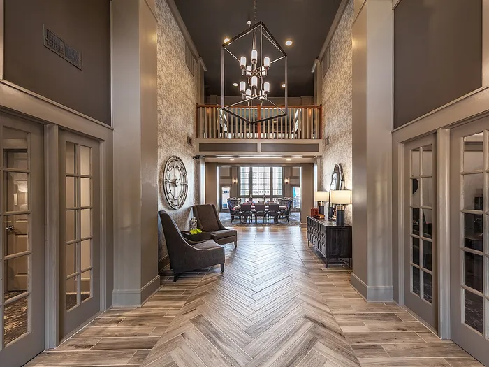 Elegant community clubhouse with chic decor, high ceiling, sophisticated lighting, and modern furnishings.