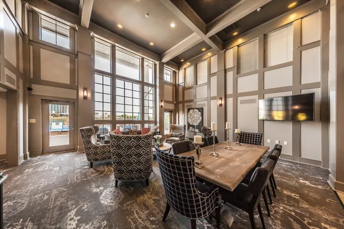 Luxurious clubhouse space with high ceilings, elegant seating areas, and large windows offering abundant natural light.