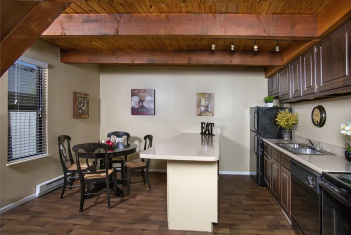 Charming kitchen with wooden beams, open dining area, and modern black appliances.