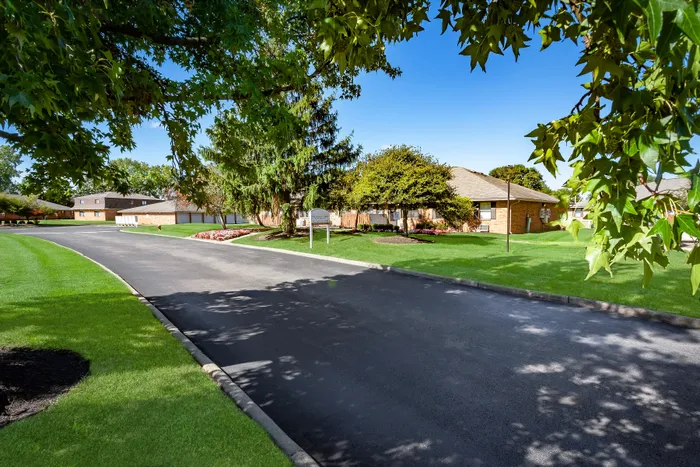 Charming suburban residence surrounded by lush greenery and a welcoming pathway, ideal for tranquil living.
