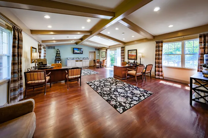 Elegant office space featuring rich hardwood floors and ample natural light from large windows.