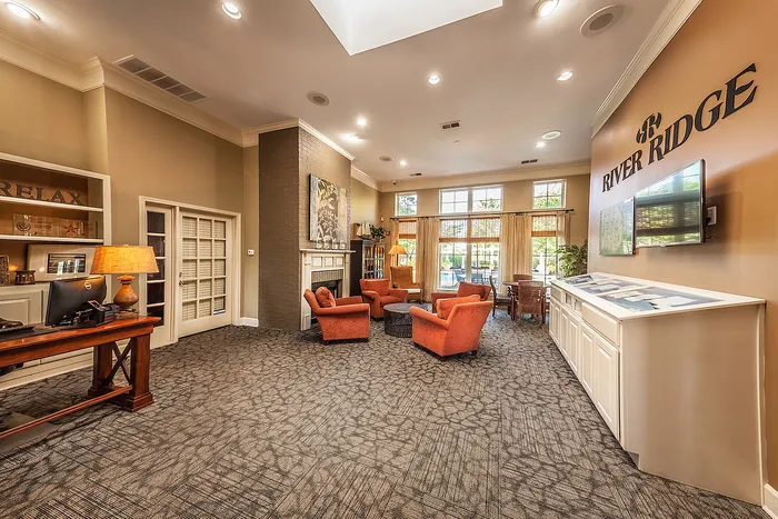 Inviting community lounge with cozy seating, elegant decor, and abundant natural light at River Ridge.