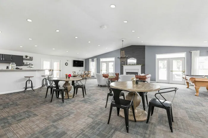 Inviting communal space featuring modern tables, cozy seating, and a stylish fireplace, perfect for social gatherings.