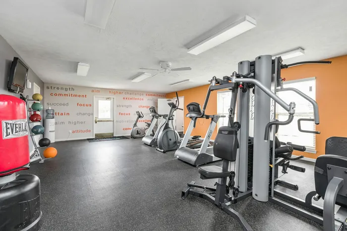 Bright and motivational home gym with modern fitness equipment, vibrant wall art, and natural lighting.