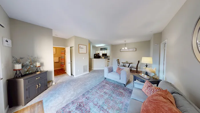 Bright and inviting living room with stylish decor, comfortable seating, and a cozy dining area, seamlessly connected to a modern kitchen.