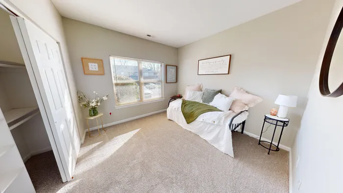 Bright and cozy bedroom with a daybed, soft neutral tones, and elegant decor, offering serene comfort and natural light.