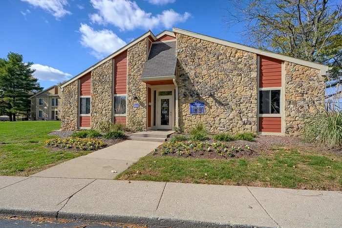 Charming leasing office with colorful siding, nestled in a landscaped garden.