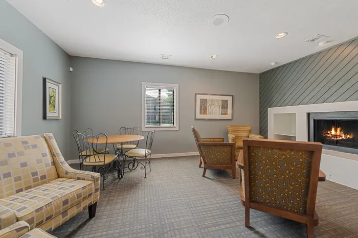 Cozy apartment lounge featuring elegant seating, a warm fireplace, and a stylish dining area ideal for relaxation and socializing.