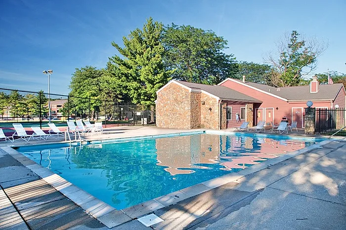 Inviting outdoor pool area surrounded by lush greenery and modern amenities, offering a serene oasis for relaxation and leisure.