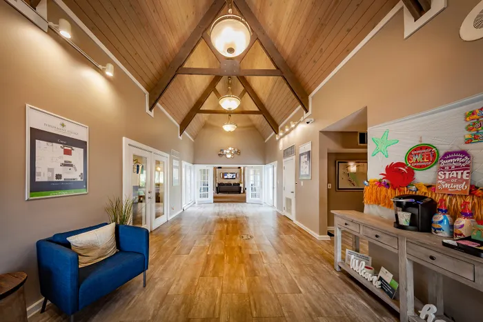 Inviting apartment lobby with high wooden ceilings, stylish lighting, and cozy seating, creating a welcoming atmosphere.