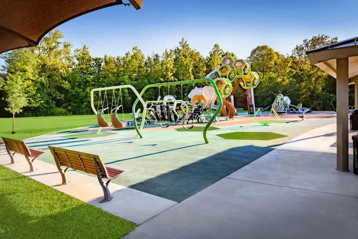 Inviting playground with modern swings, unique climbing structures, and vibrant green surroundings, ideal for family fun.
