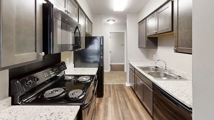 Sleek modern kitchen with stainless steel appliances, elegant countertops, and warm wood flooring.