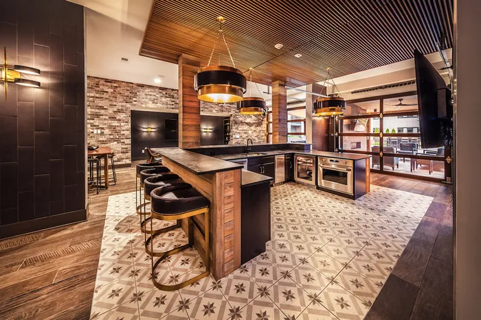 Luxurious clubhouse kitchen with modern appliances, stylish tile flooring, and elegant pendant lighting, perfect for entertaining.