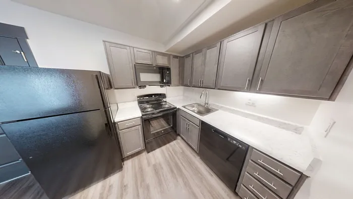 Modern kitchen with sleek gray cabinetry, stainless steel appliances, and elegant marble countertops.