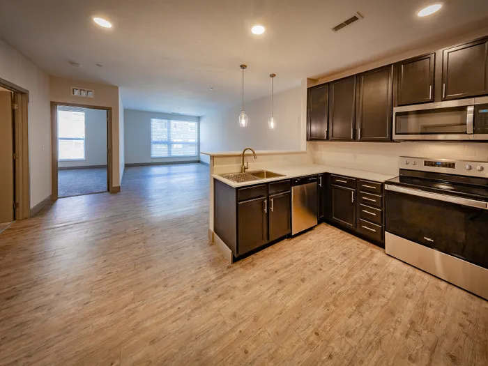 Modern open-concept apartment with sleek kitchen, spacious living area, and ample natural light.