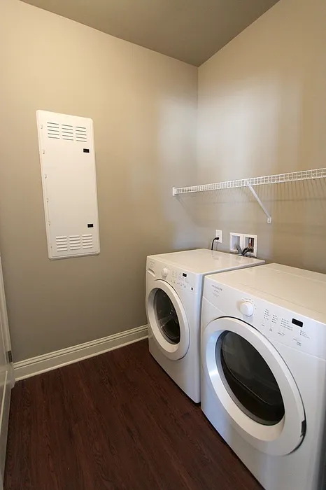 Chic laundry room featuring energy-efficient washer and dryer on elegant hardwood flooring.