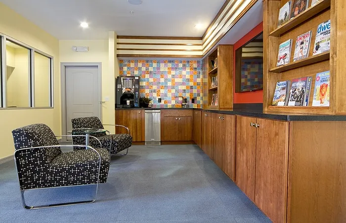 Modern lounge area with cozy armchairs and coffee station.